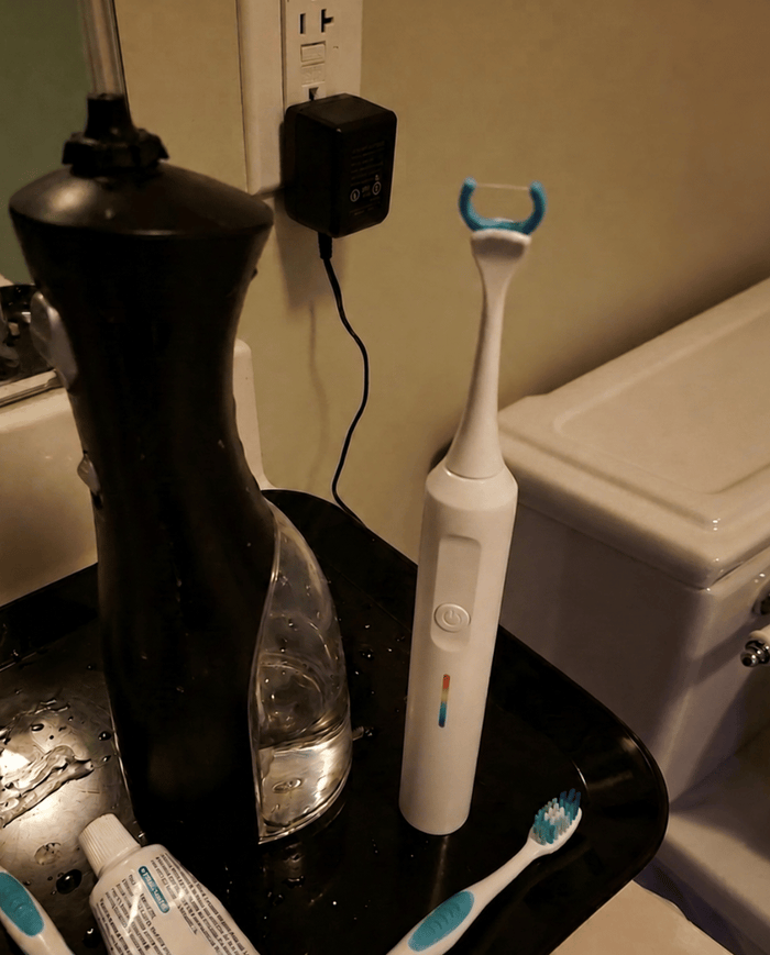 Essoon flosser standing next to an old water flosser on a bathroom counter