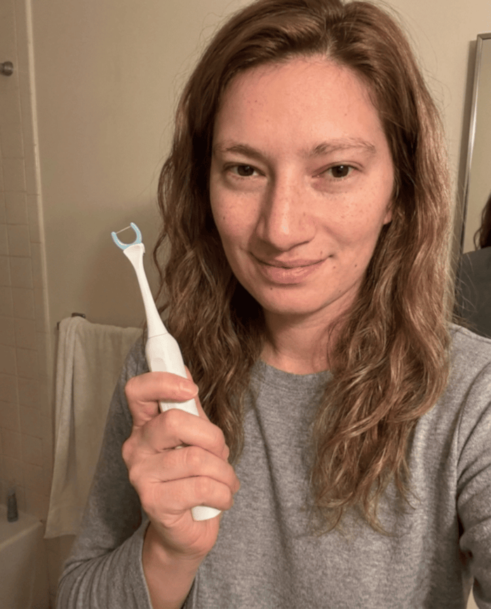 Fiona D. holding the Essoon flosser in her bathroom