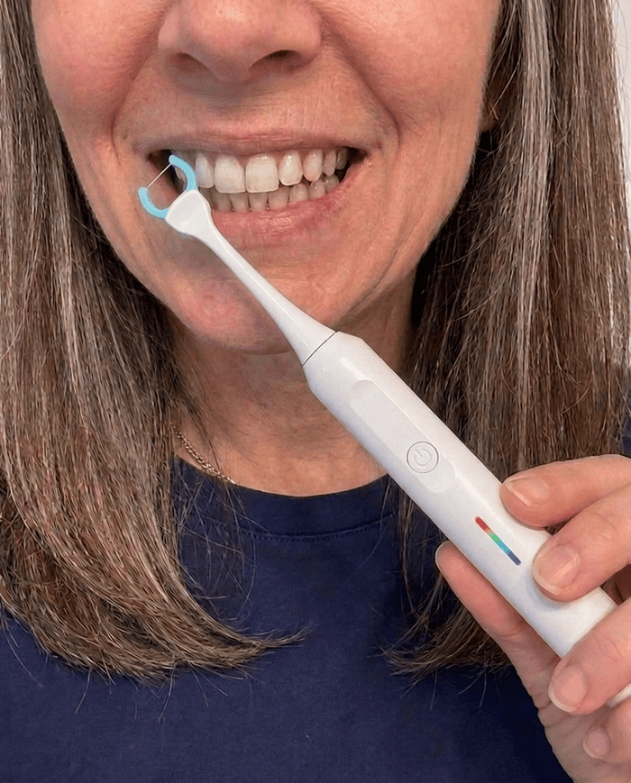 Megan T. using the Essoon flosser on her teeth