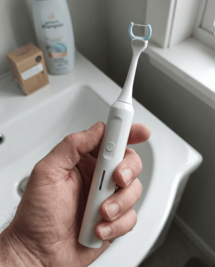 Tom H. holding the Essoon flosser over a bathroom sink